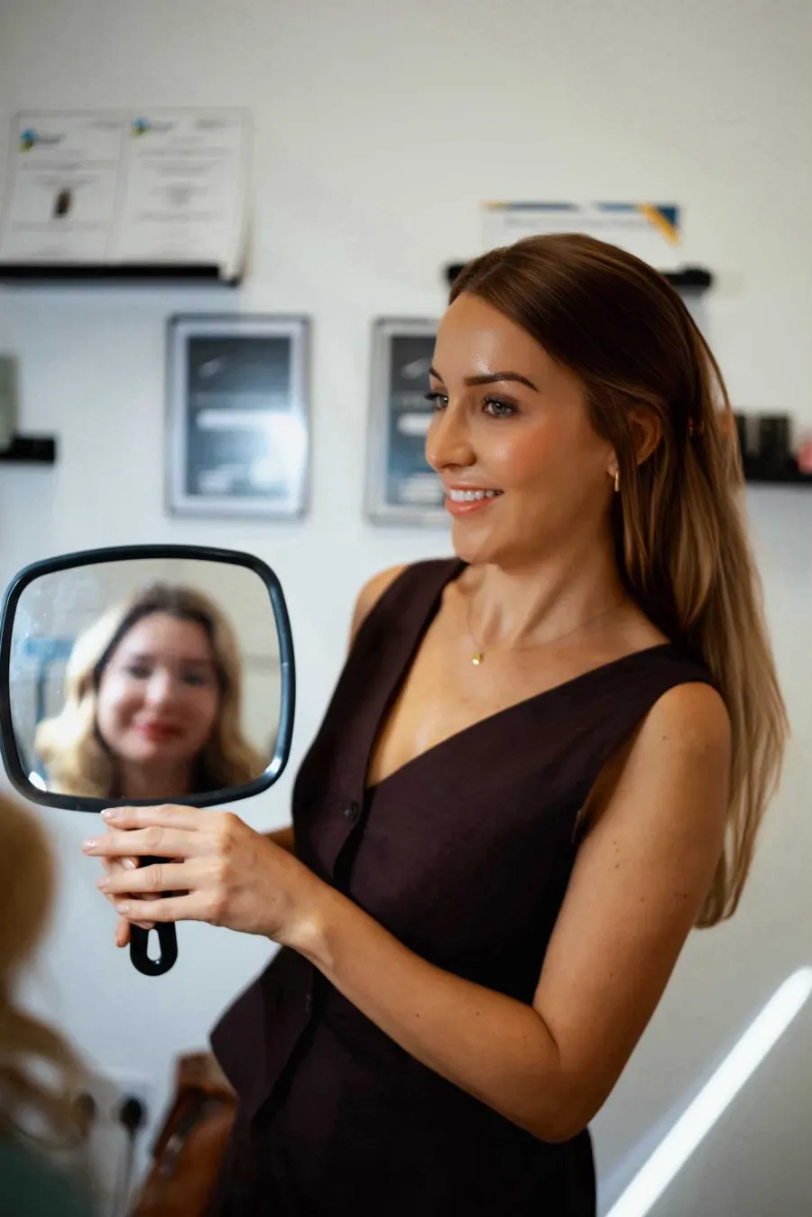 A client seeing her new brows in the mirror at S A Cosmetics